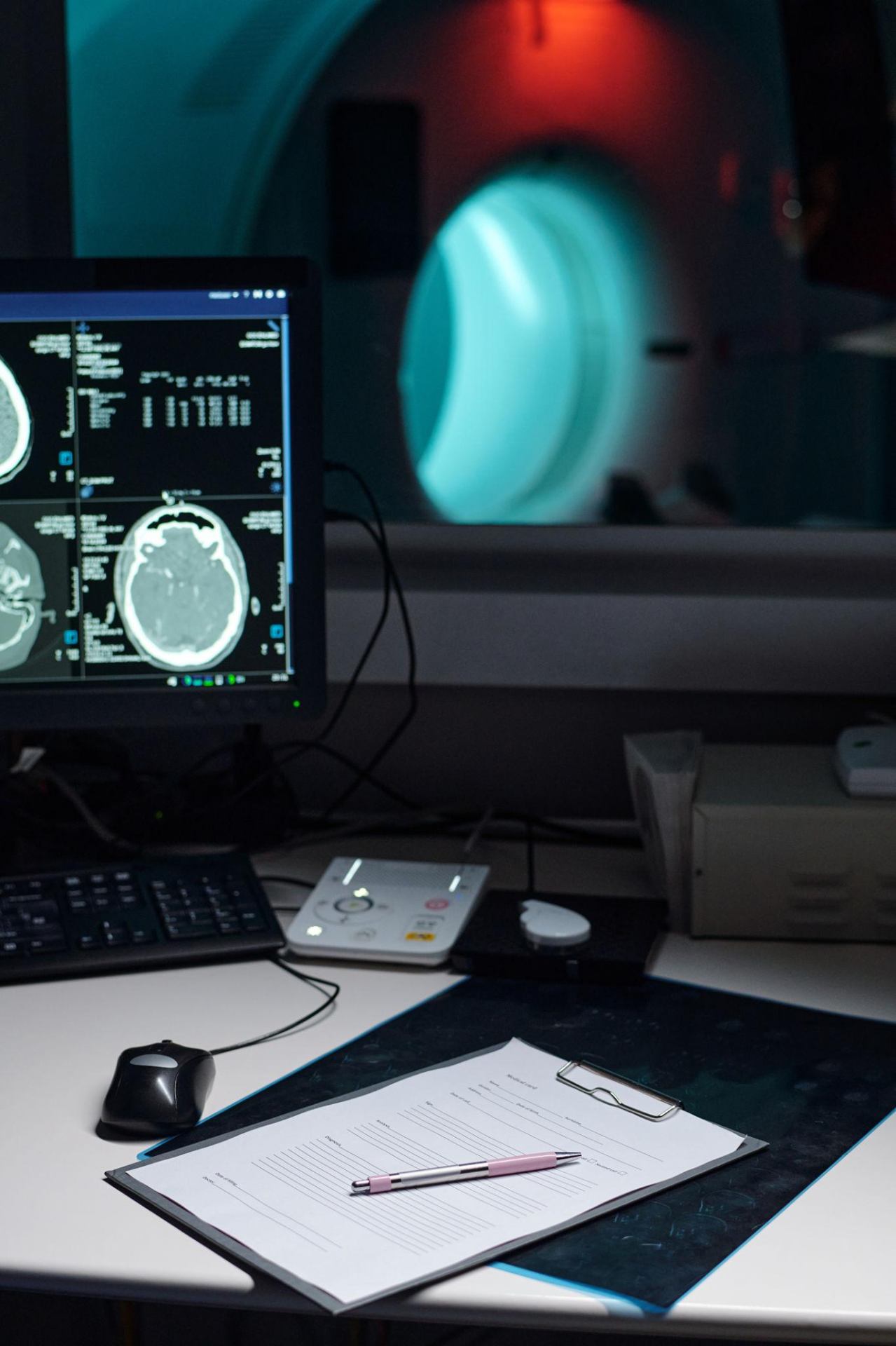 Sala de diagnóstico neurológico con monitor mostrando una resonancia cerebral junto a un equipo de neuroimagen